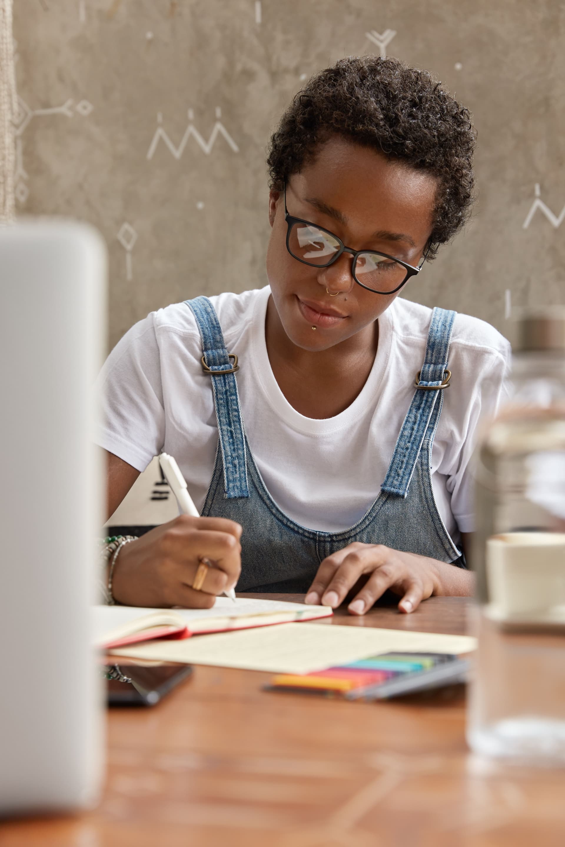 boyish_woman_with_short_hairstyle_black_skin_takes_notes_indoors_fd8816c054.jpg